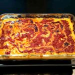 En ugnsform med vegetarisk zucchinilasagne som har en gyllene yta.