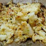 Ugnsbakad blomkål med vitlök och parmesan på bakplåtspapper.