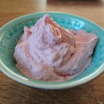 Skål med rosa fryst yoghurt gjord på jordgubbar, serverad i en liten skål.