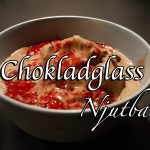 En skål med chokladglass toppad med jordgubbssås.