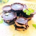 Chokladkonfekter med fyllning och mynta på en tallrik.