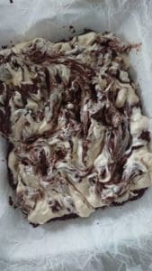 En bit chokladfudge med vaniljkräm som är swirlad ovanpå.