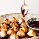 Kokostoppar på en tallrik med smält choklad i en skål bredvid.