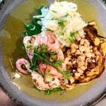 En tallrik med fisk, räkor, grillad kål och strimlad grönsallad.