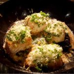 Parmesangratinerad torskrygg med örter i en stekpanna.