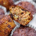 Zucchinimuffins med en bit av en muffin som visar inuti med chokladbitar.