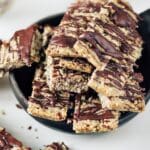 En skål med hemgjorda fröbars toppade med choklad, staplade på varandra.
