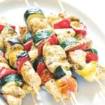 Grillade kycklingspett med zucchini, tomater och paprika på träspett.