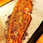 Grillad laxfilé med sesamfrön på en plåt med bakplåtspapper.